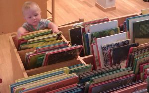 Barn som bläddrar i ett boktråg. 