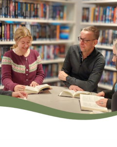 En kvinna och en man som sitter på biblioteket och läser. 